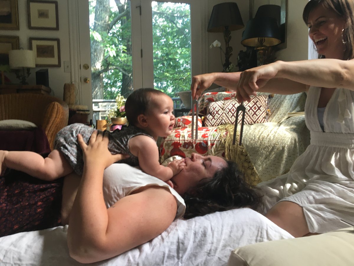 Ashley holds tuning forks during a session with a mother and baby.
